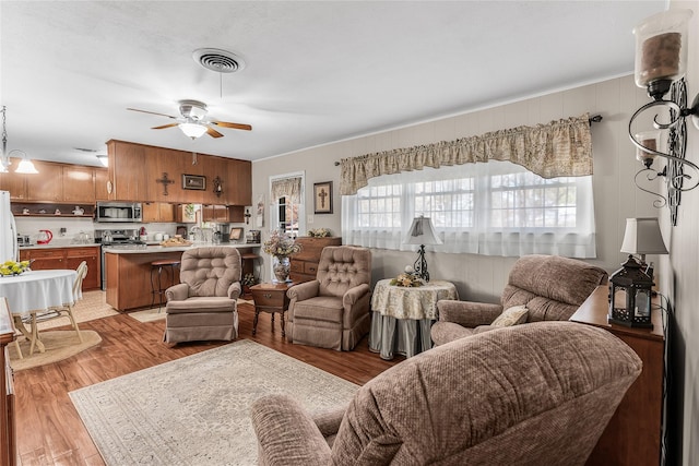 living room featuring ceiling fan and light wood-type flooring