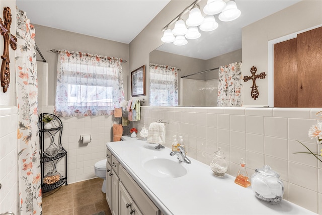 bathroom featuring vanity, toilet, tile walls, and walk in shower