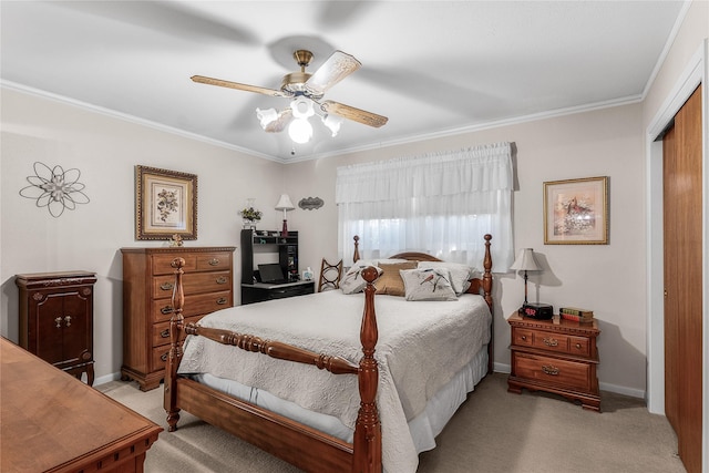 carpeted bedroom with ceiling fan, crown molding, and a closet