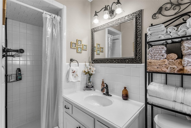 bathroom with walk in shower, vanity, toilet, and tile walls