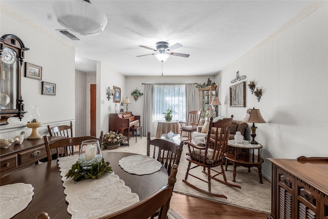 dining room featuring a textured ceiling, hardwood / wood-style flooring, and ceiling fan