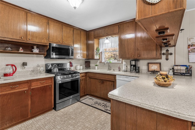 kitchen featuring kitchen peninsula, decorative backsplash, sink, and stainless steel appliances