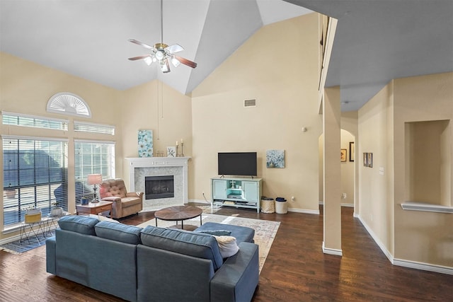 living room featuring a premium fireplace, high vaulted ceiling, dark wood-type flooring, and ceiling fan