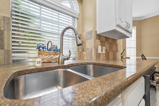 122 Wentwood Dr, Murphy, TX 75094 - kitchen view of backsplash, white cabinetry, crown molding, and dark stone countertops