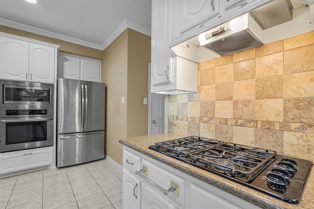 kitchen with white cabinets, decorative backsplash, light tile patterned floors, ornamental molding, and appliances with stainless steel finishes