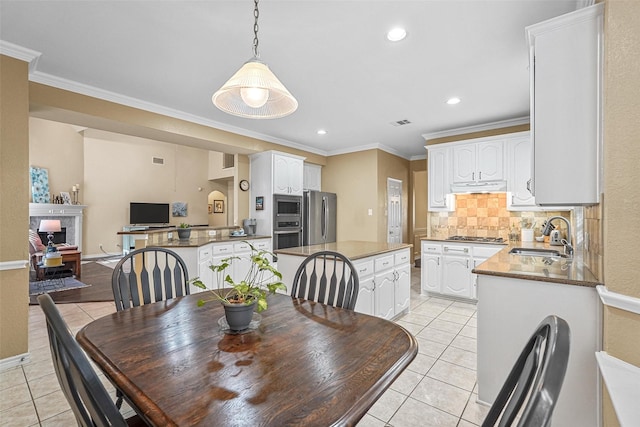 dining room featuring light tile patterned floors, ornamental molding, and sink