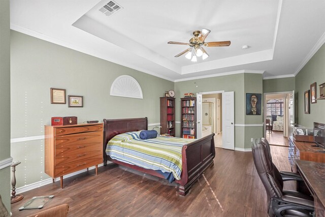 bedroom featuring ornamental molding, a tray ceiling, ceiling fan, and dark wood-type flooring