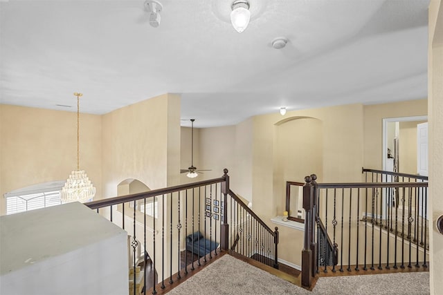 hall featuring a chandelier and carpet