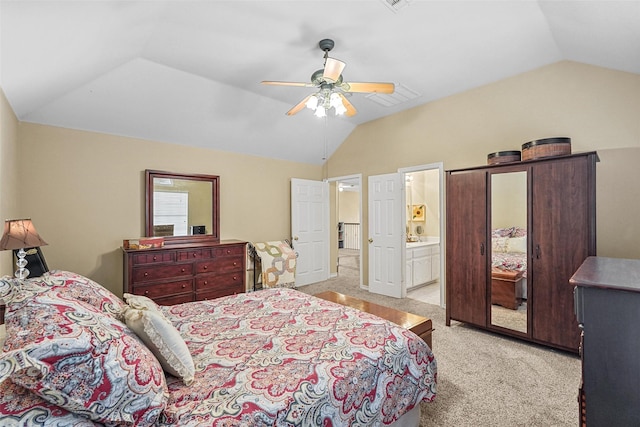 bedroom with light carpet, ensuite bathroom, vaulted ceiling, and ceiling fan