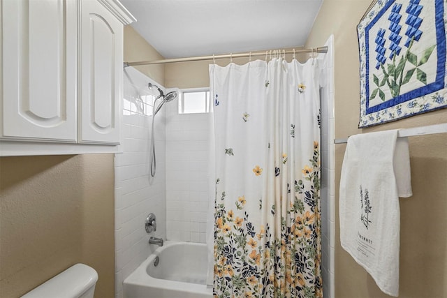 bathroom with shower / tub combo and toilet