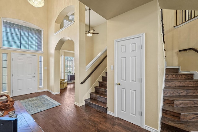 entrance foyer featuring ceiling fan, a towering ceiling, and dark hardwood / wood-style floors