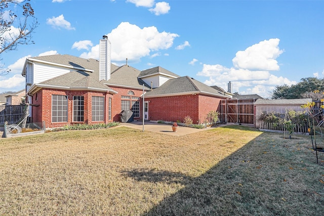 back of house featuring a patio area and a lawn