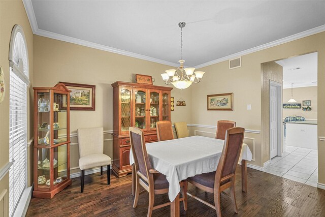 dining room with a notable chandelier, dark hardwood / wood-style flooring, and crown molding