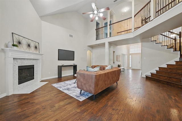 122 Wentwood Dr, Murphy, TX 75094 - living area with ceiling fan, a fireplace, wood finished floors, a high ceiling, and stairs