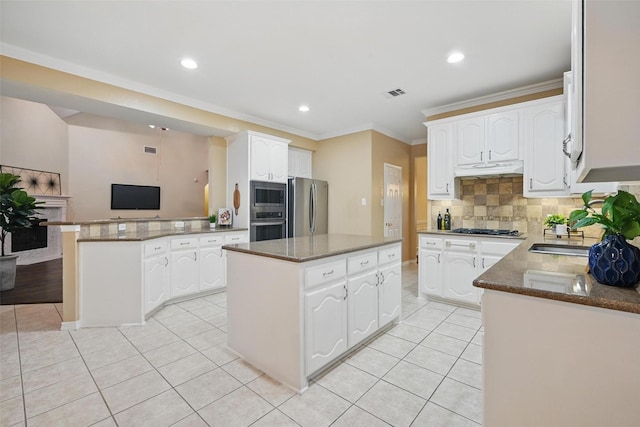 122 Wentwood Dr, Murphy, TX 75094 - kitchen featuring stainless steel appliances, a kitchen island, light tile patterned flooring, tasteful backsplash, and white cabinetry