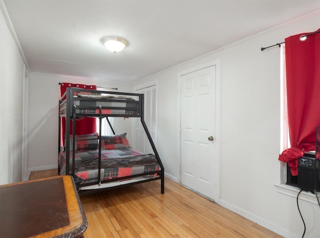 bedroom with hardwood / wood-style floors and crown molding