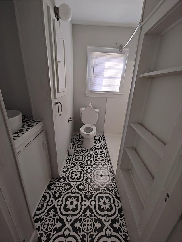 bathroom featuring toilet, tile patterned floors, and walk in shower