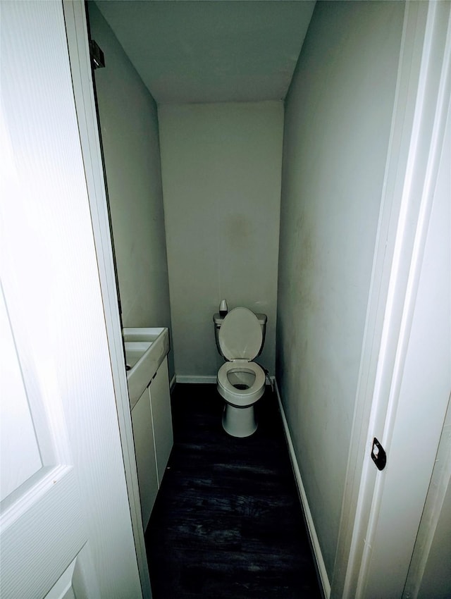 bathroom featuring wood-type flooring and toilet