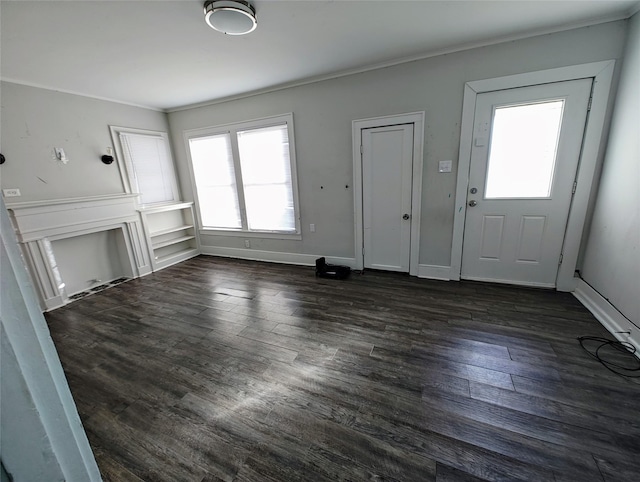 foyer entrance with ornamental molding and dark wood-type flooring