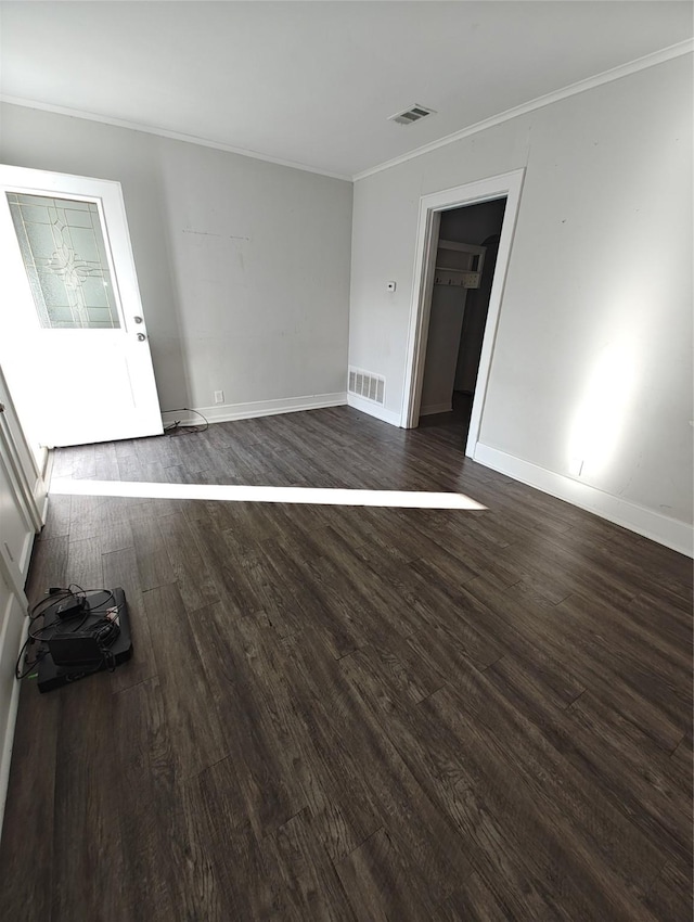 empty room featuring dark hardwood / wood-style floors and ornamental molding