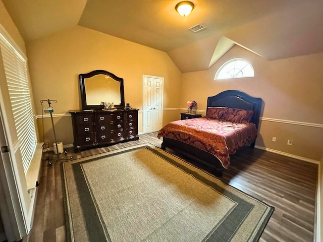 bedroom with a closet, dark hardwood / wood-style flooring, and vaulted ceiling