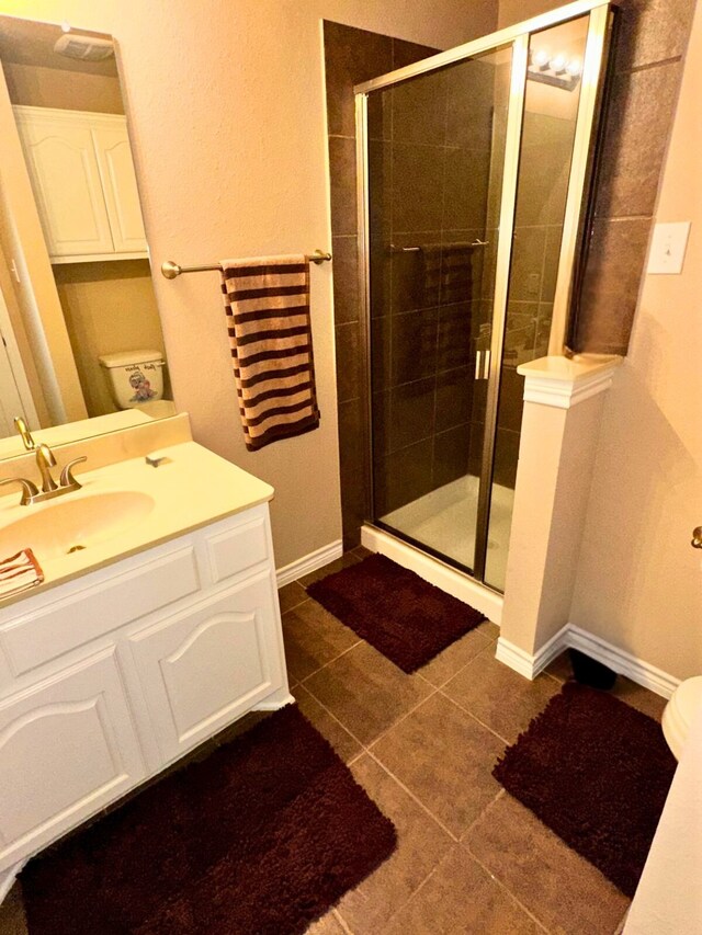 bathroom featuring a shower with door, tile patterned flooring, and toilet