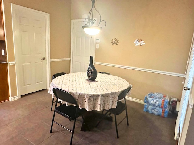 dining area featuring dark tile patterned floors