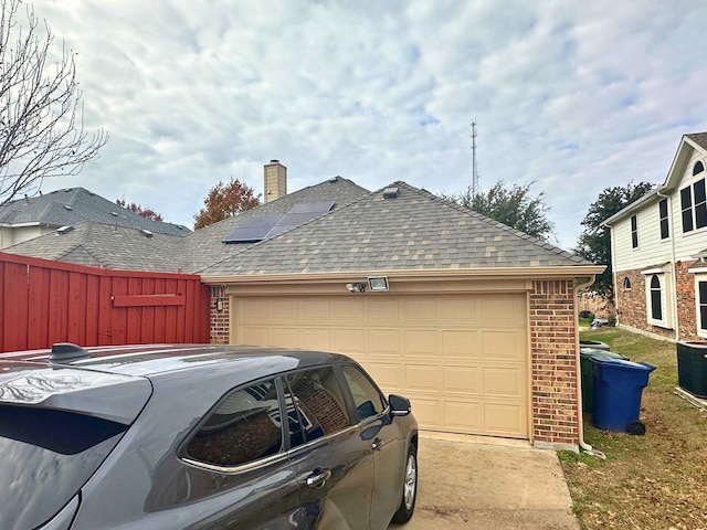 view of side of property with solar panels and a garage