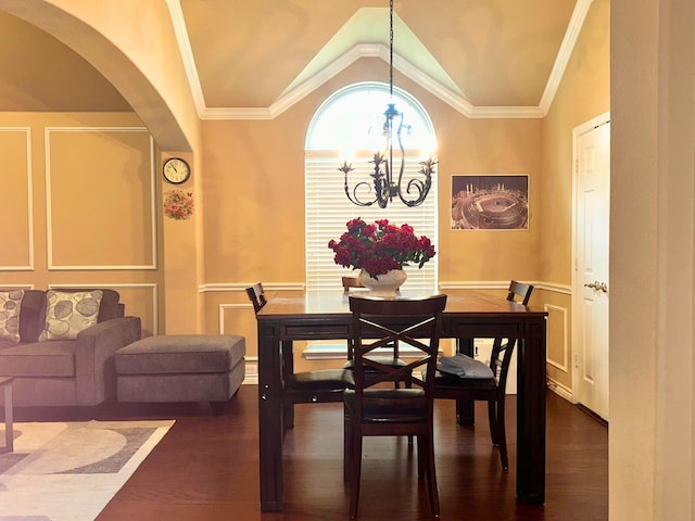 dining area with an inviting chandelier, dark hardwood / wood-style flooring, ornamental molding, and vaulted ceiling