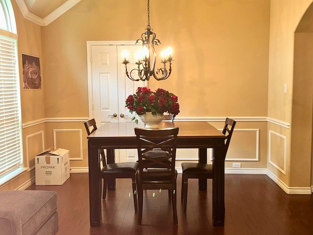 dining room with dark hardwood / wood-style flooring, crown molding, lofted ceiling, and a notable chandelier