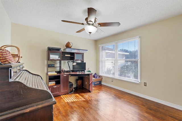 home office featuring a textured ceiling, light wood-type flooring, and ceiling fan