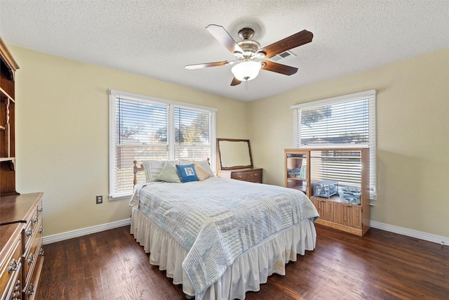 bedroom featuring a textured ceiling, dark hardwood / wood-style floors, and ceiling fan