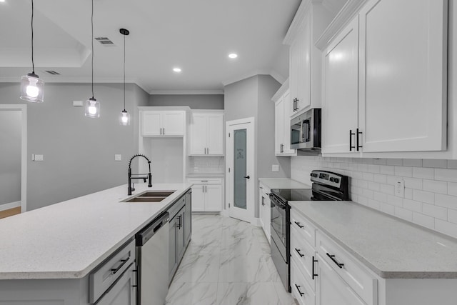 kitchen with stainless steel appliances, sink, decorative light fixtures, white cabinets, and an island with sink