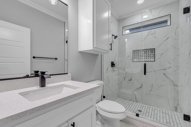 bathroom with vanity, toilet, a shower with shower door, and ornamental molding