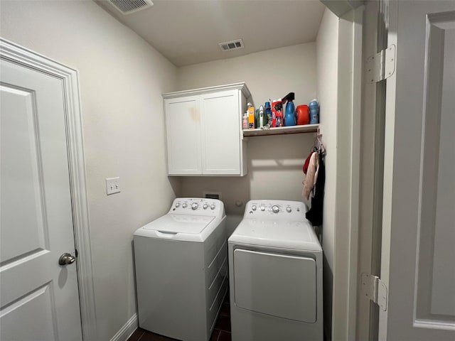 washroom with cabinets, dark tile patterned flooring, and washing machine and clothes dryer