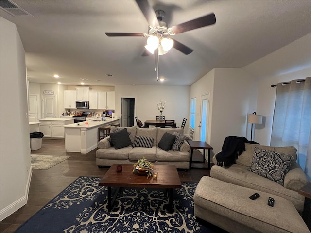 living room featuring dark tile patterned floors and ceiling fan