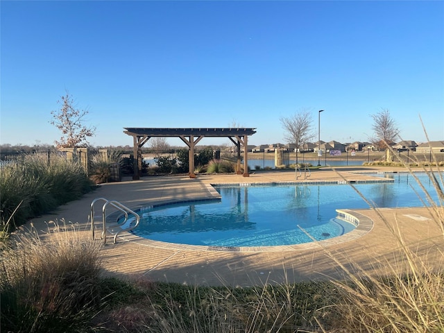 view of pool with a pergola, a water view, and a patio area