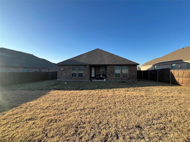 rear view of house featuring a lawn