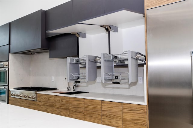 kitchen featuring wall chimney exhaust hood, sink, and stainless steel appliances