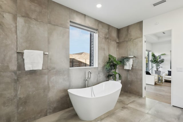 bathroom with a bath and concrete flooring