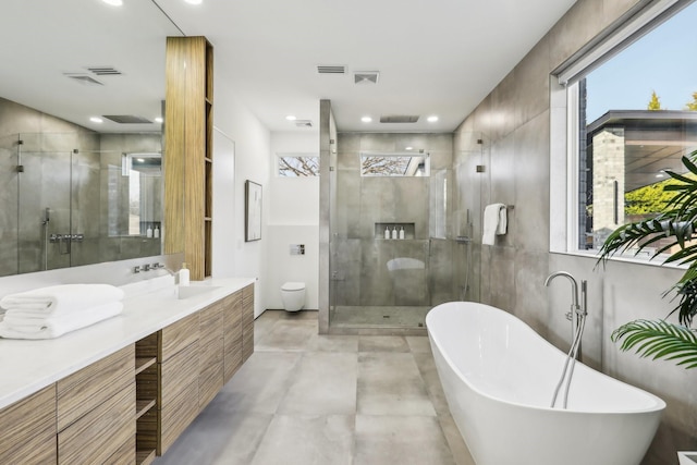 bathroom featuring concrete flooring, separate shower and tub, and vanity