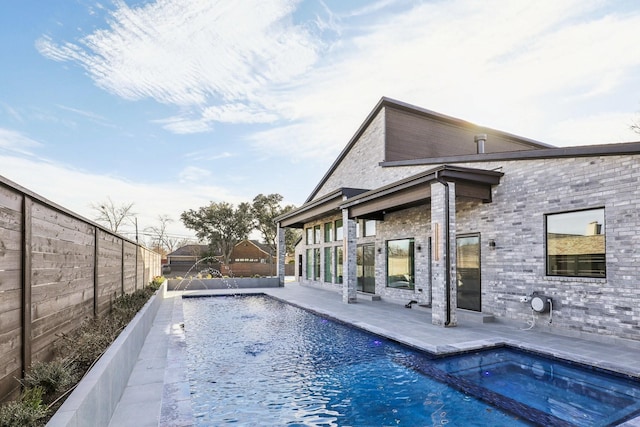 view of pool featuring pool water feature, a patio area, and a hot tub