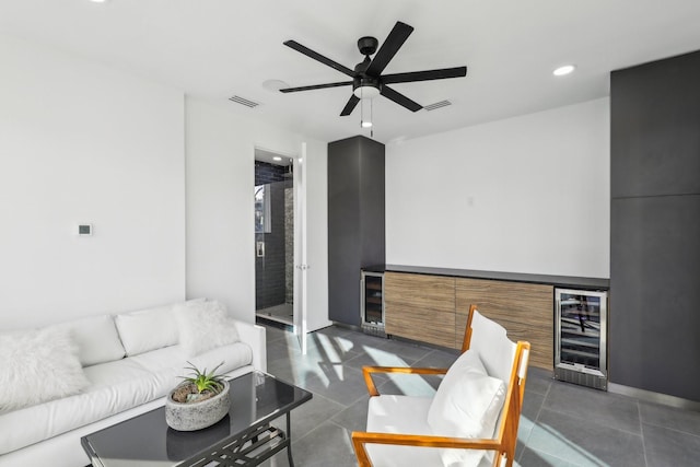 living room featuring ceiling fan, bar area, and beverage cooler