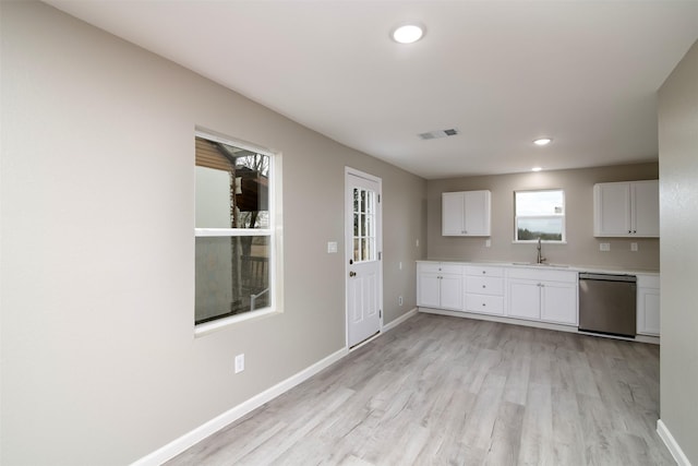 kitchen featuring dishwasher, white cabinets, light hardwood / wood-style flooring, and sink