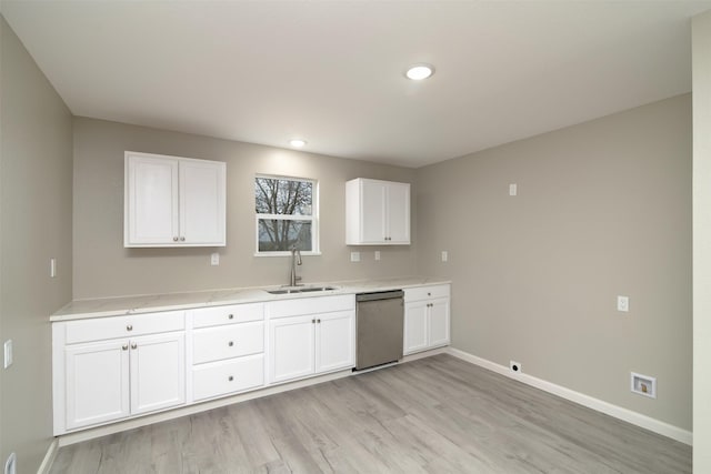 kitchen featuring sink, white cabinets, stainless steel dishwasher, and light hardwood / wood-style flooring