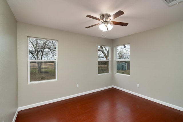 empty room with ceiling fan and dark hardwood / wood-style flooring