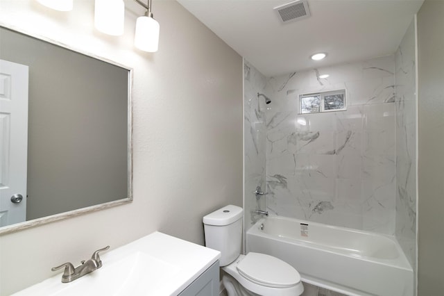 full bathroom with vanity, tiled shower / bath combo, and toilet