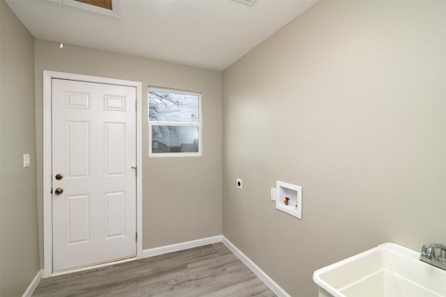 laundry area featuring hookup for a washing machine, light hardwood / wood-style flooring, electric dryer hookup, and sink