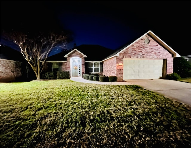 ranch-style house featuring a garage and a yard