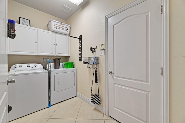 laundry room with cabinets, independent washer and dryer, and light tile patterned floors